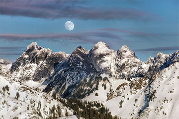 Snowcapped mountains under a moonlit sky
