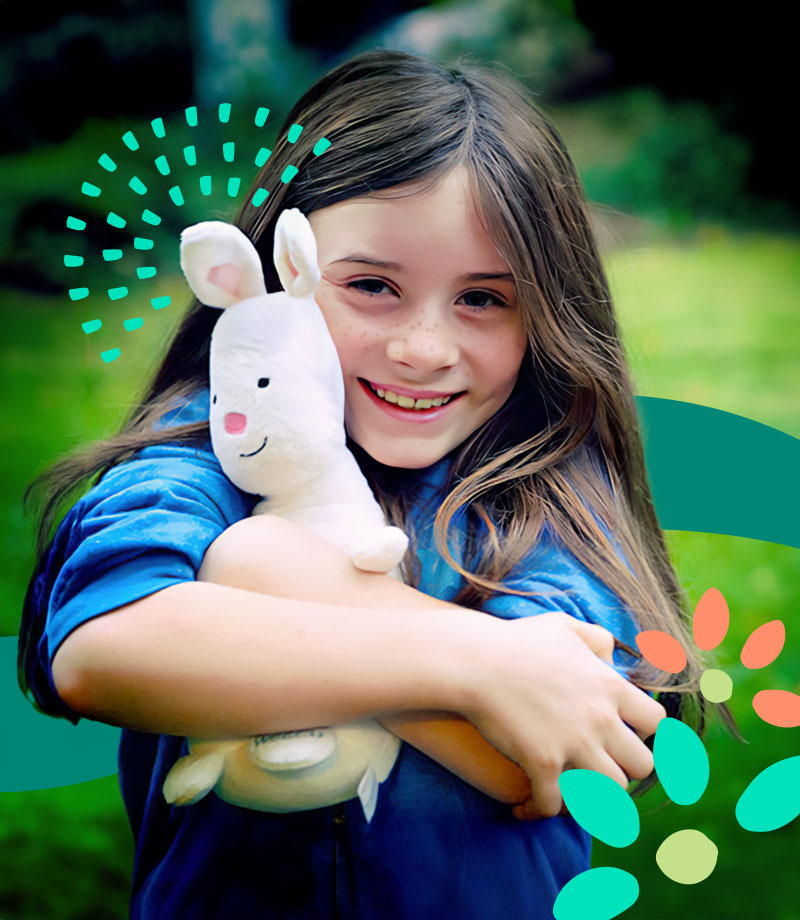 A young girl hugs a WSECU Munny Bunny stuffed animal