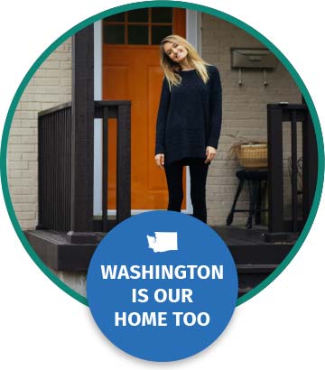 A woman in her 30s stands and smiles on the front porch of her new home. Text below reads Washington is our home too.