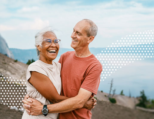 A senior couple laughing while hugging each other