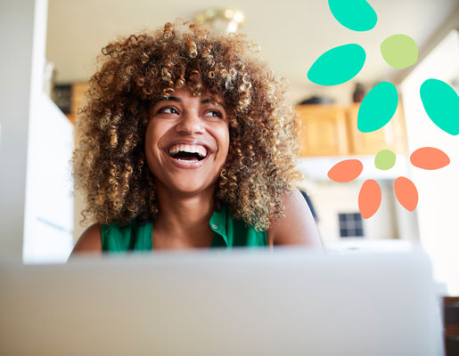 A woman smiling in front of a laptop