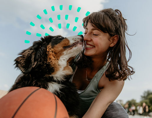 A dog kissing a woman's nose