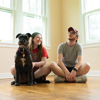 two children sitting in an empty house with a dog
