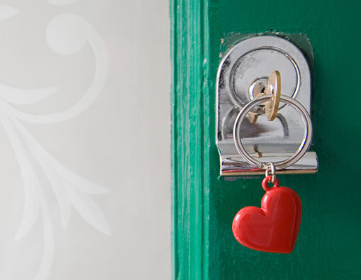 key in a teal door attached to a heart shaped keychain