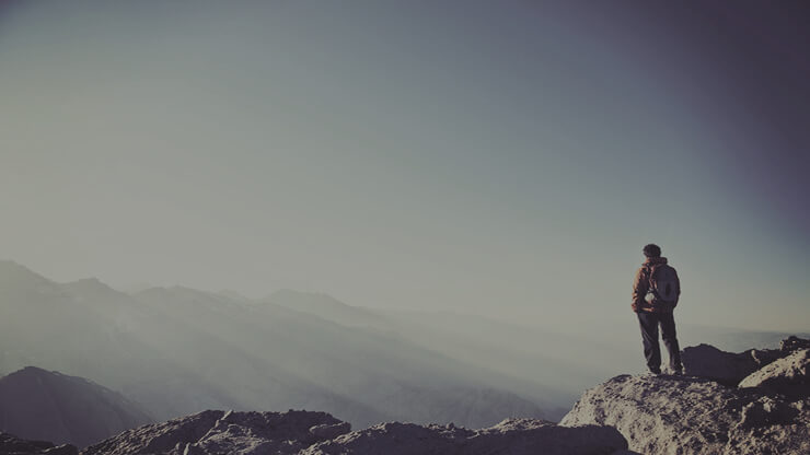 Man looking out from mountain top