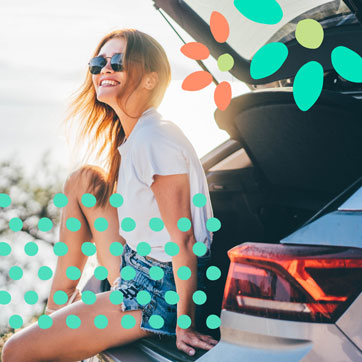 A girl sitting on the open trunk of a car