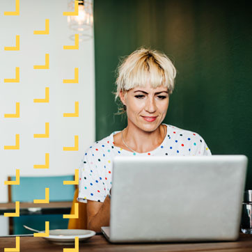 a woman using her laptop at a cafe