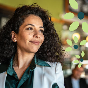 a woman wearing a button up shirt and blazer smiling softly