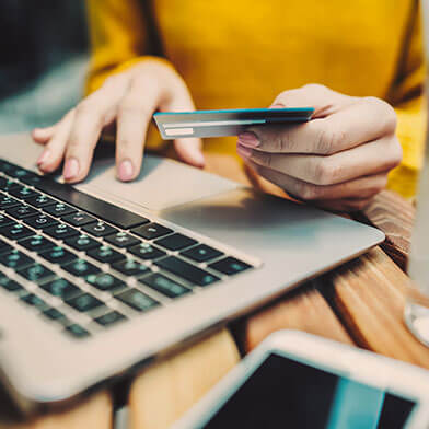 Person entering credit card information on laptop