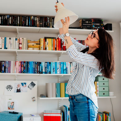 Woman screwing in light bulb