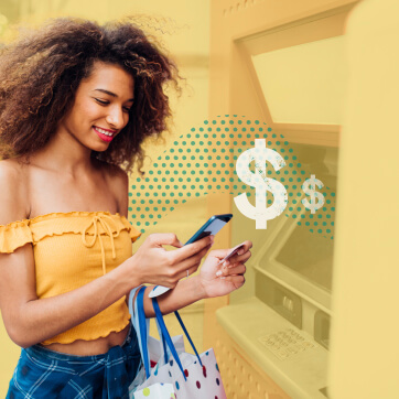 Woman in front of an ATM looking at her phone