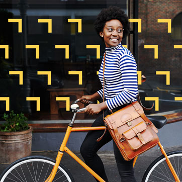 a woman riding a bike past a storefront