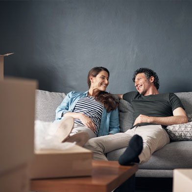 couple sitting on a couch smiling at each other
