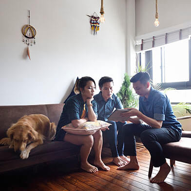 People chatting on couch with dog