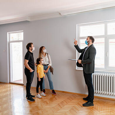 Family talking to a realtor inside home