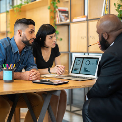 People chatting around a laptop