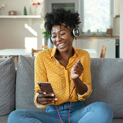 woman listening to music on a couch