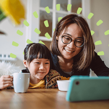 mom and daughter looking at a phone while drinking coffee