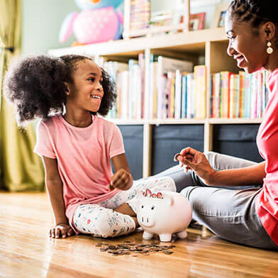 mother and daughter counting money from piggie bank