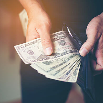 Person counting cash in wallet