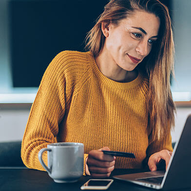 woman entering credit card information on laptop