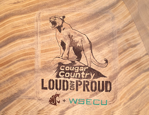 Top-down view of the WSU crop art featuring a cougar standing on a rock with the words "Cougar Country Loud and Proud" and the WSU and WSECU logos below it.