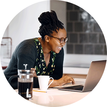 A woman sitting at a laptop on a kitchen counter