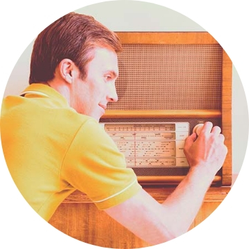 A man adjusting the dial of a 1970s radio