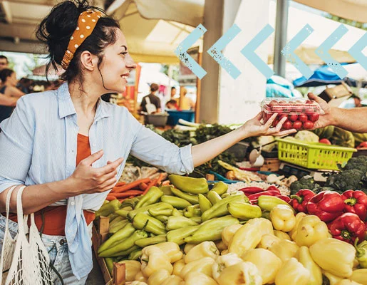 A woman receiving tomatoes at a produce stand