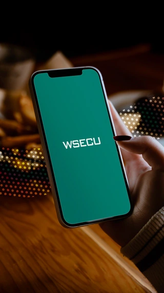 a smartphone displaying a teal screen with "WSECU" written across the middle in white